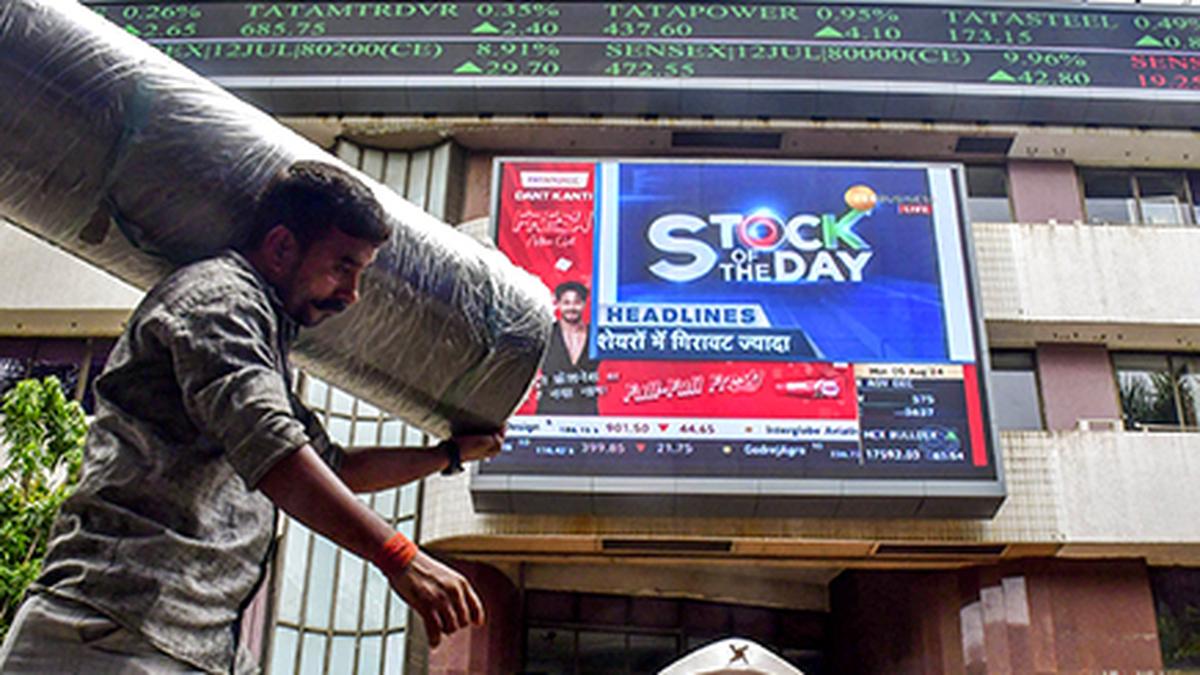 Markets settle almost flat in volatile trade; Nifty hits lifetime high